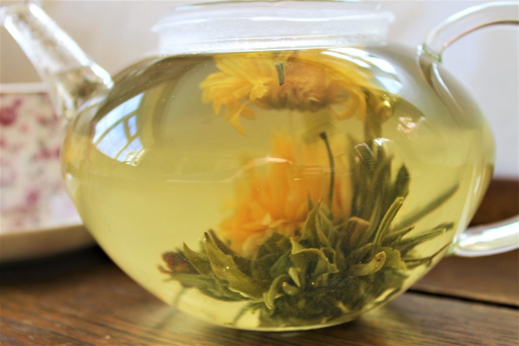 Marigold blooming tea in glass teapot