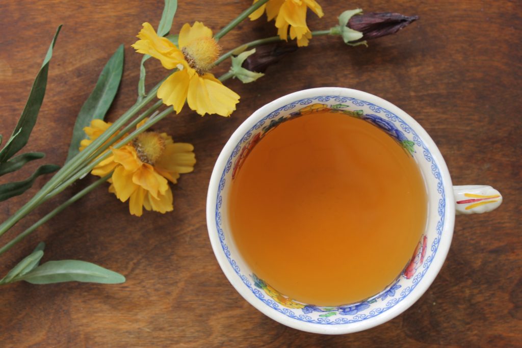 cinnamon and ginger tea in cup with flowers