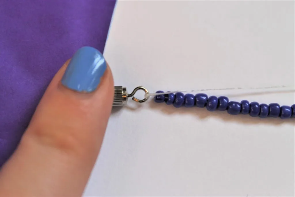finger on strung bead bracelet clasp