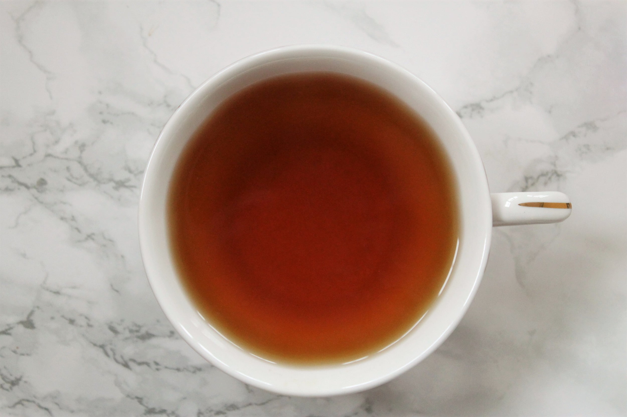 brown cinnamon tea in white teacup